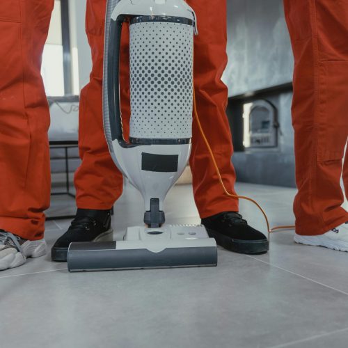 pexels-photo-6195122-6195122 Team of professional cleaners in red uniforms using a vacuum cleaner indoors.